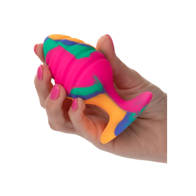 CalExotics Cheeky Tie-Dye Swirl Anal Plug con diseño multicolor, sujetado con la mano.