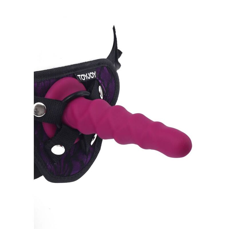 Detalle del dildo estriado rosa Get Real en un arnés negro.