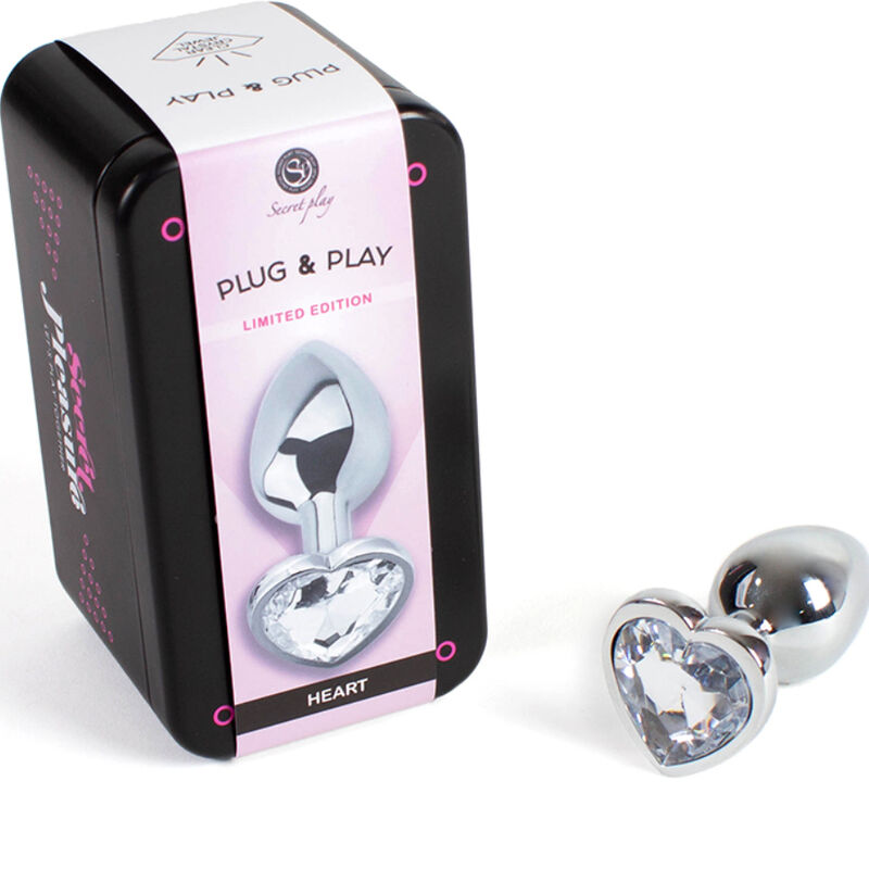 Tapón anal metálico Secretplay con corazón transparente, junto a la caja del producto.