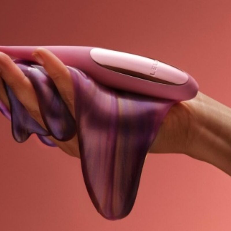 LELO DOT Travel morado sostenido en la mano, con accesorio translúcido.