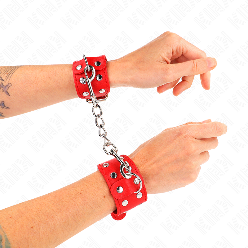 Detalle de las muñequeras KINK rojas unidas por una cadena metálica.
