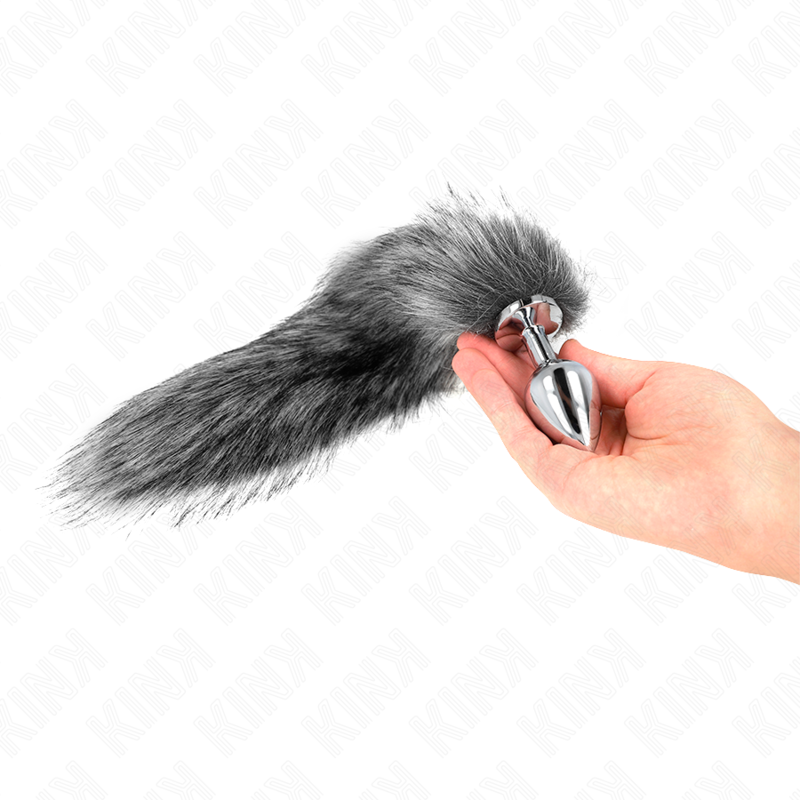 Plug anal Kink Pleasure Plugs plateado con cola sintética gris, sostenido con la mano.