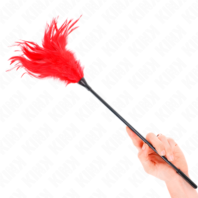 Plumero de plumas KINK rojo con mango negro, sujetado con la mano.