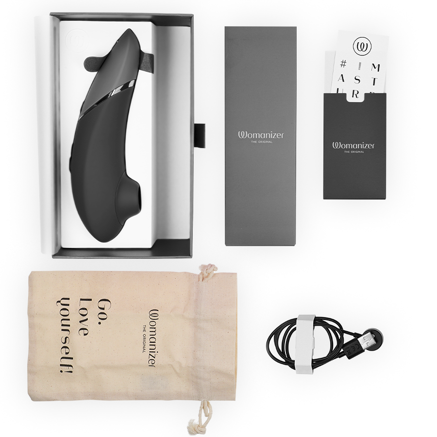 Womanizer NEXT negro con caja abierta y accesorios incluidos