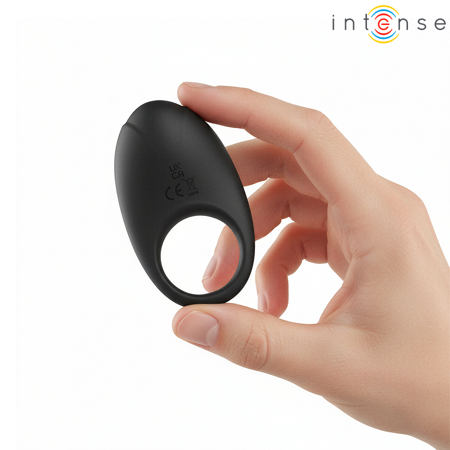 Detalle del anillo vibrador negro Intense Merlotte sujeto entre los dedos.