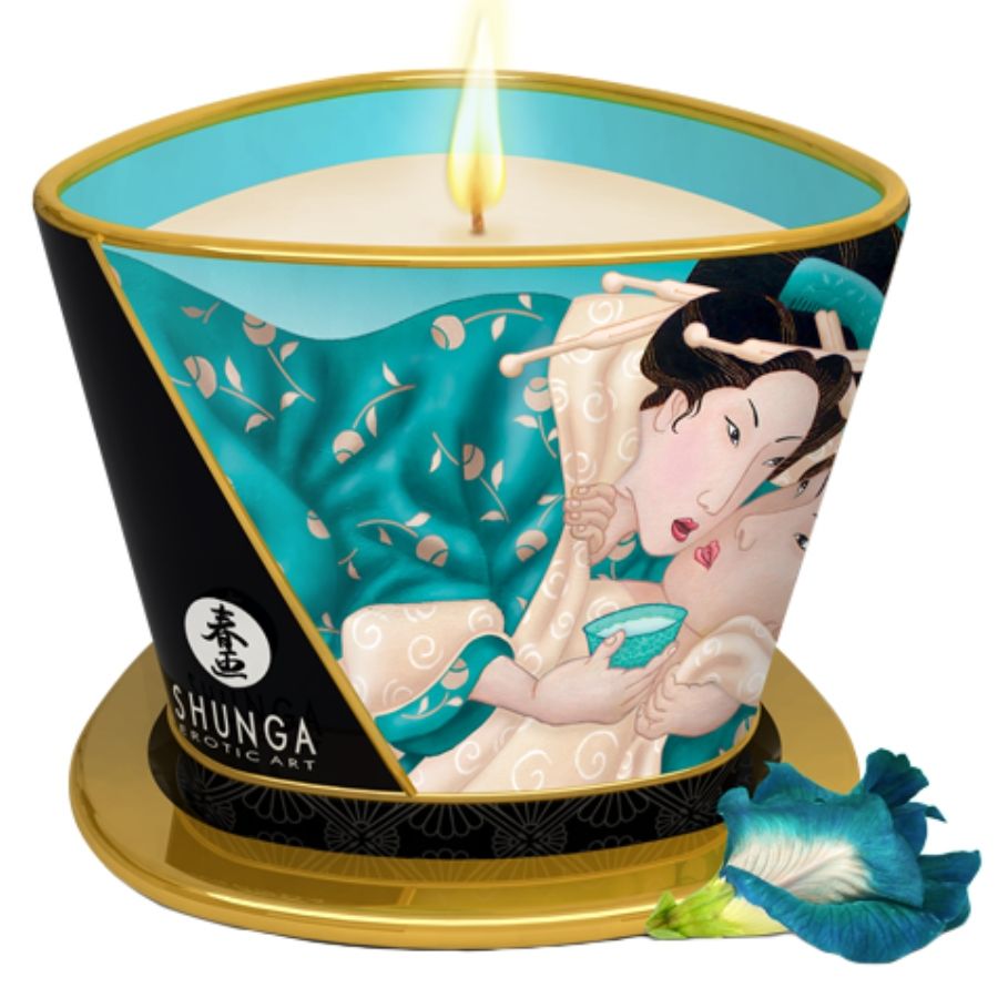 Vela de masaje Shunga Candles Island Blossoms en lata turquesa y dorada, con llama encendida.