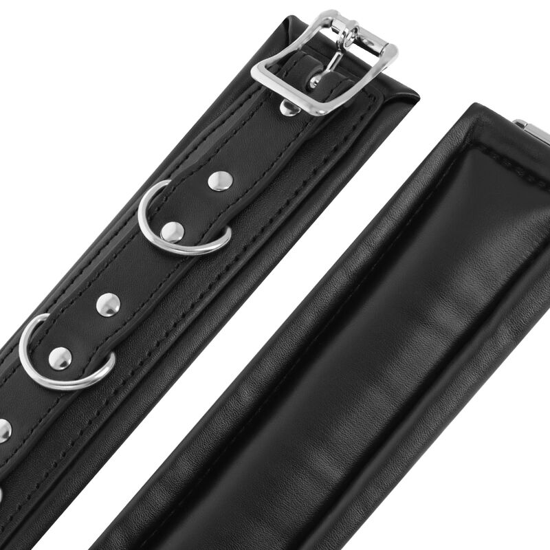 Detalle de las esposas de muñeca acolchadas Darkness Bondage en negro, con hebilla y argollas metálicas.